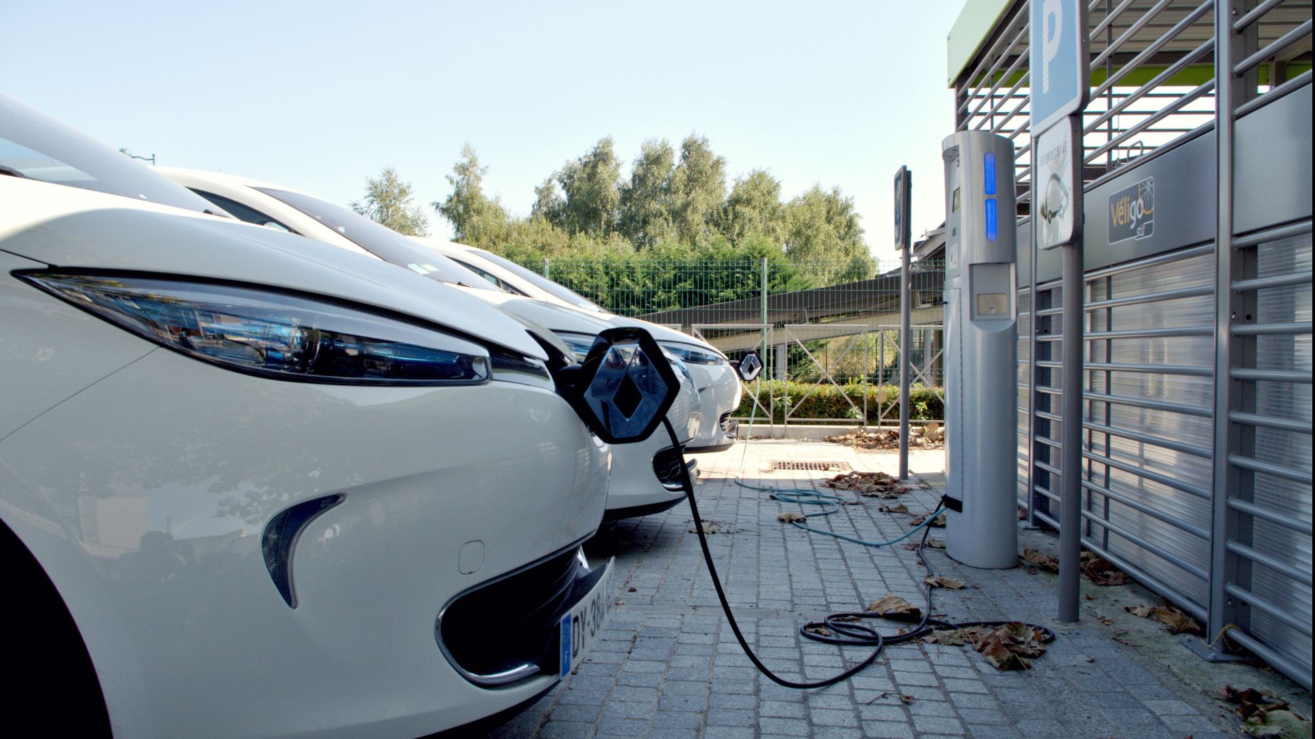 Three cars parked at electric vehicle charging stations