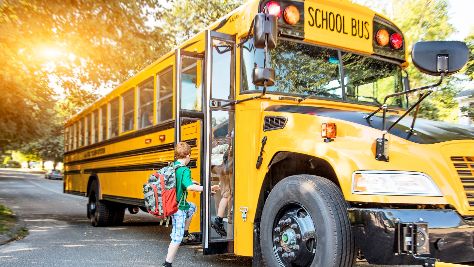 Children getting on a yellow school bus