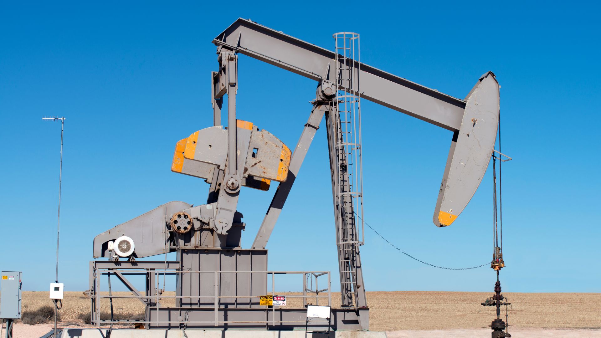 Closeup view of an oil well against a blue sky in the desert