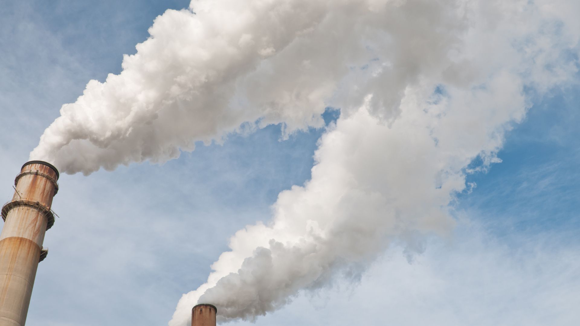 Smoke stacks billowing white smoke into the air