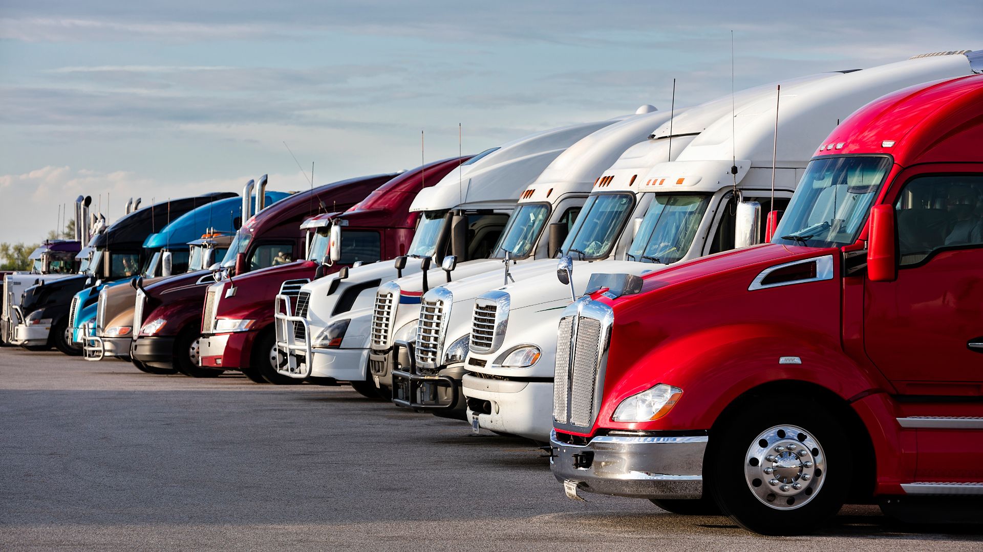 A row of semi trucks lined up like a hero shot in a Transformers movie. Autobots, roll out!