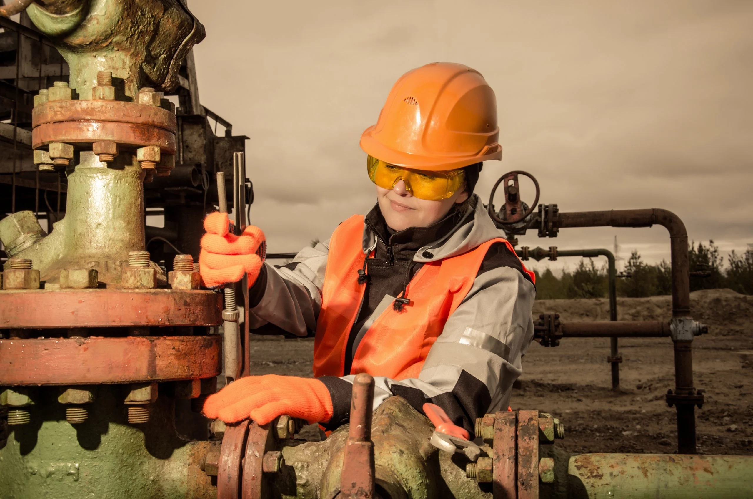 Female oil and gas worker working on machinery