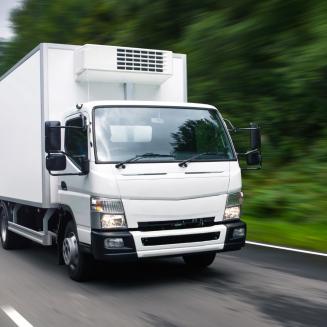 An electric delivery truck driving down a road
