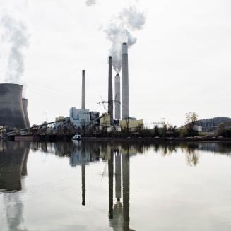 Smoke rises from the smokestacks of an industrial plant.