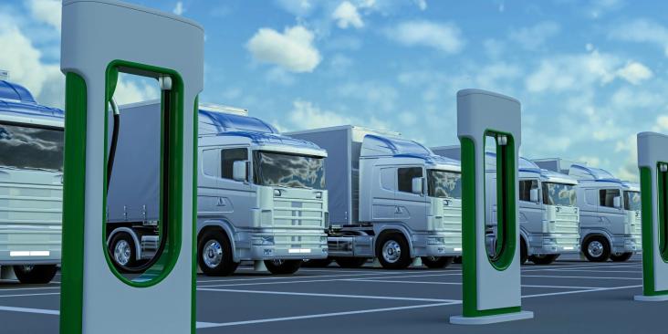 Row of electric trucks with charging stations in front of them