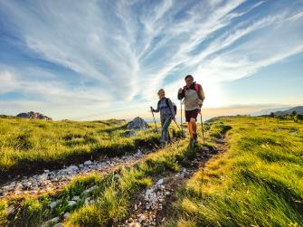 2 people walking on a trail