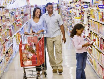 Family of three in the cereal aisle at a grocery store